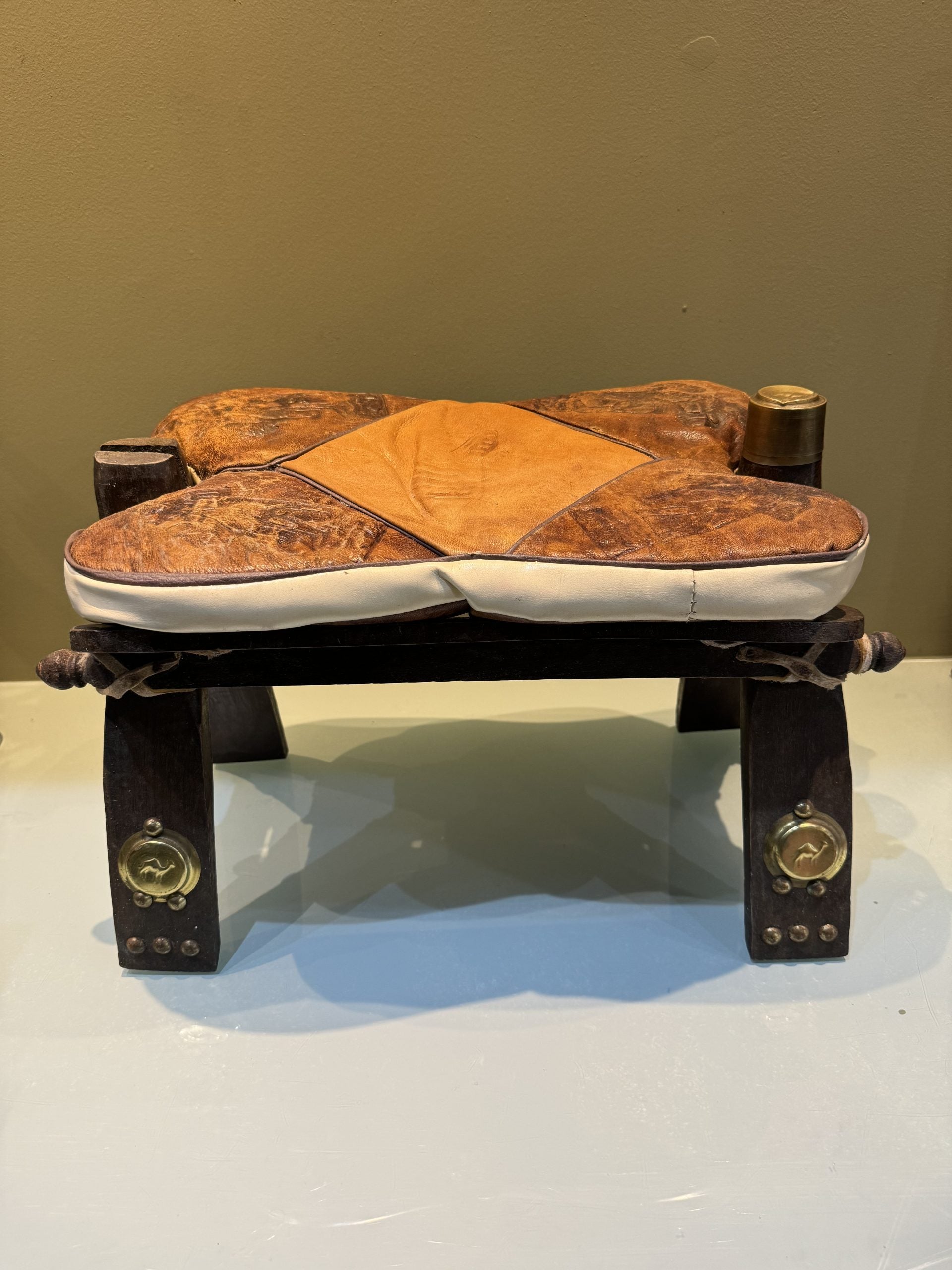 Egyptian stools, camel saddles in wood, leather and brass